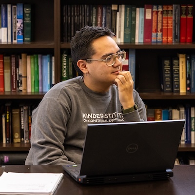 Mathias Smith contemplates his response to a question, his laptop open in front of him.