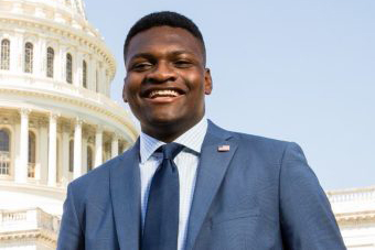 Paul Odu wears a blue suit in front of the US Capitol building.