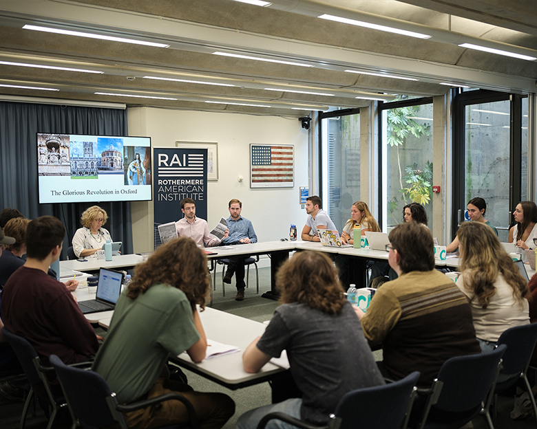 People sit at tables arranged in a square.