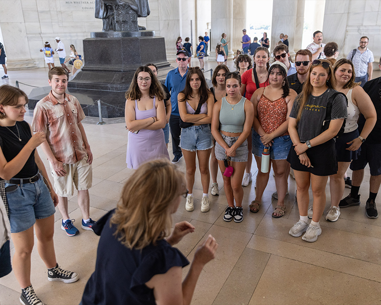 A group of college students listen to a tour guide in Washington, DC