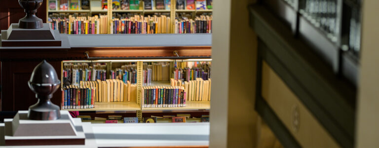 View of library shelves at the bottom of a staircase.