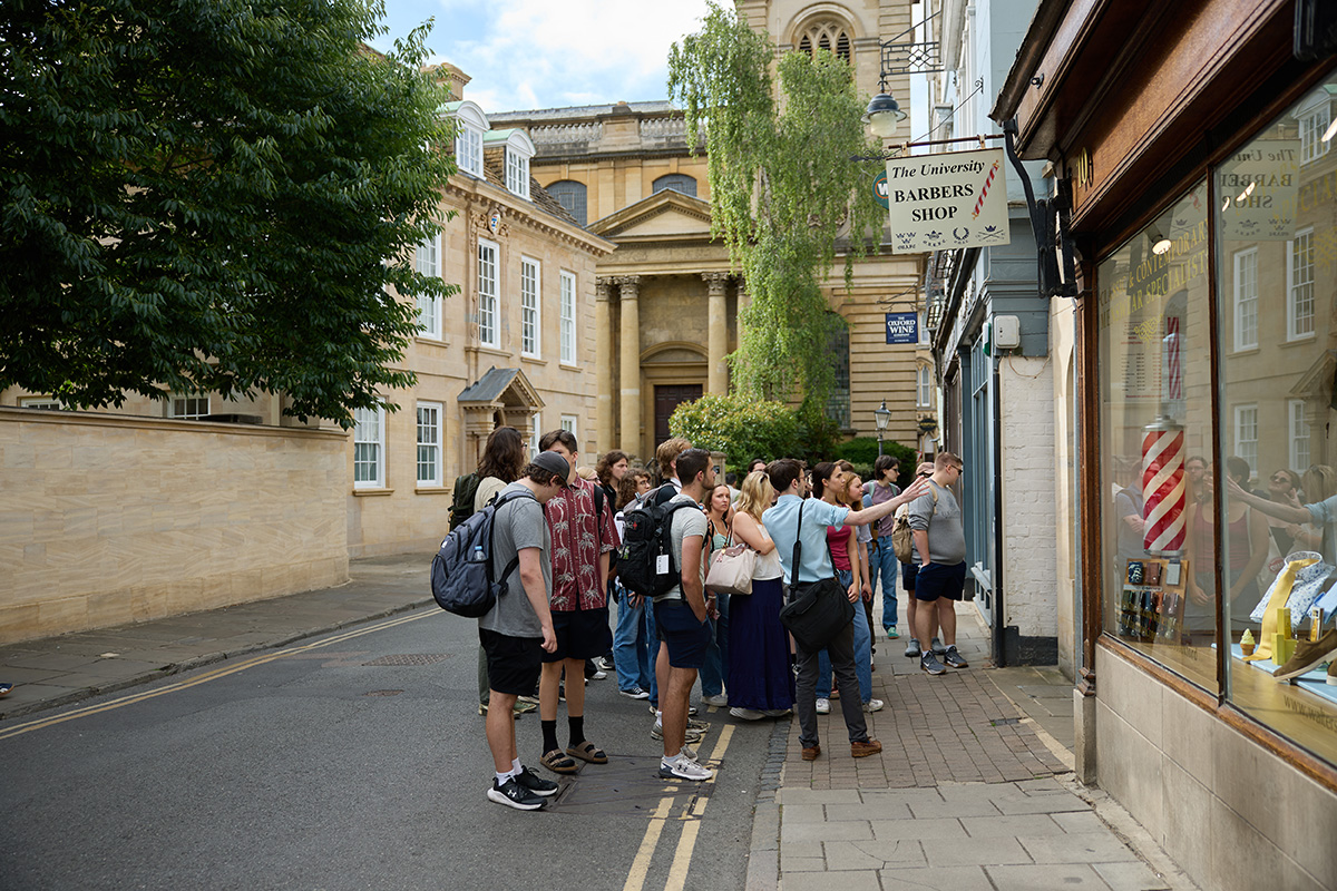 A group of students stops outside a shop on the streets of Oxford.
