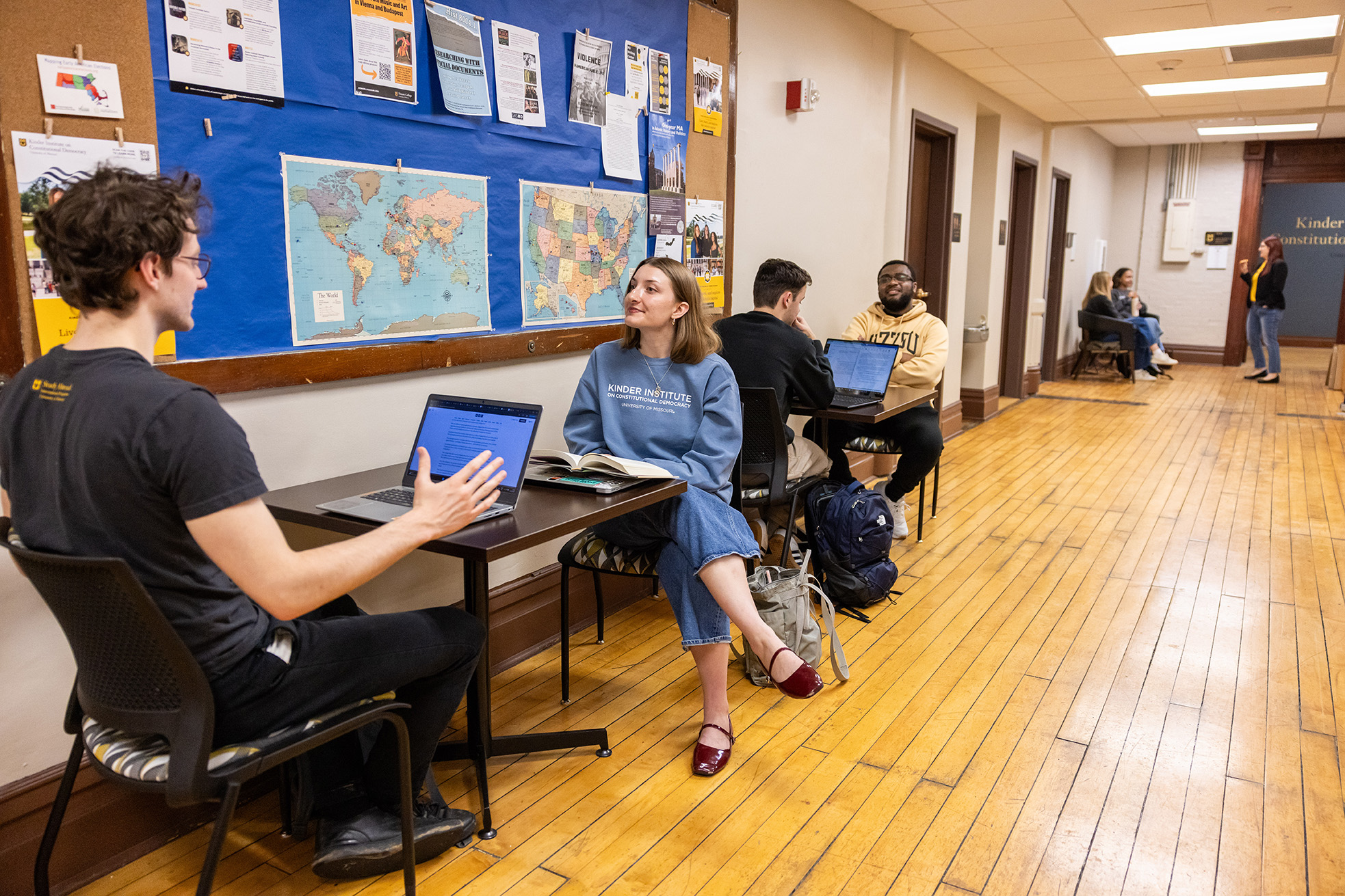 Students stare forward at an Oxford dinner.