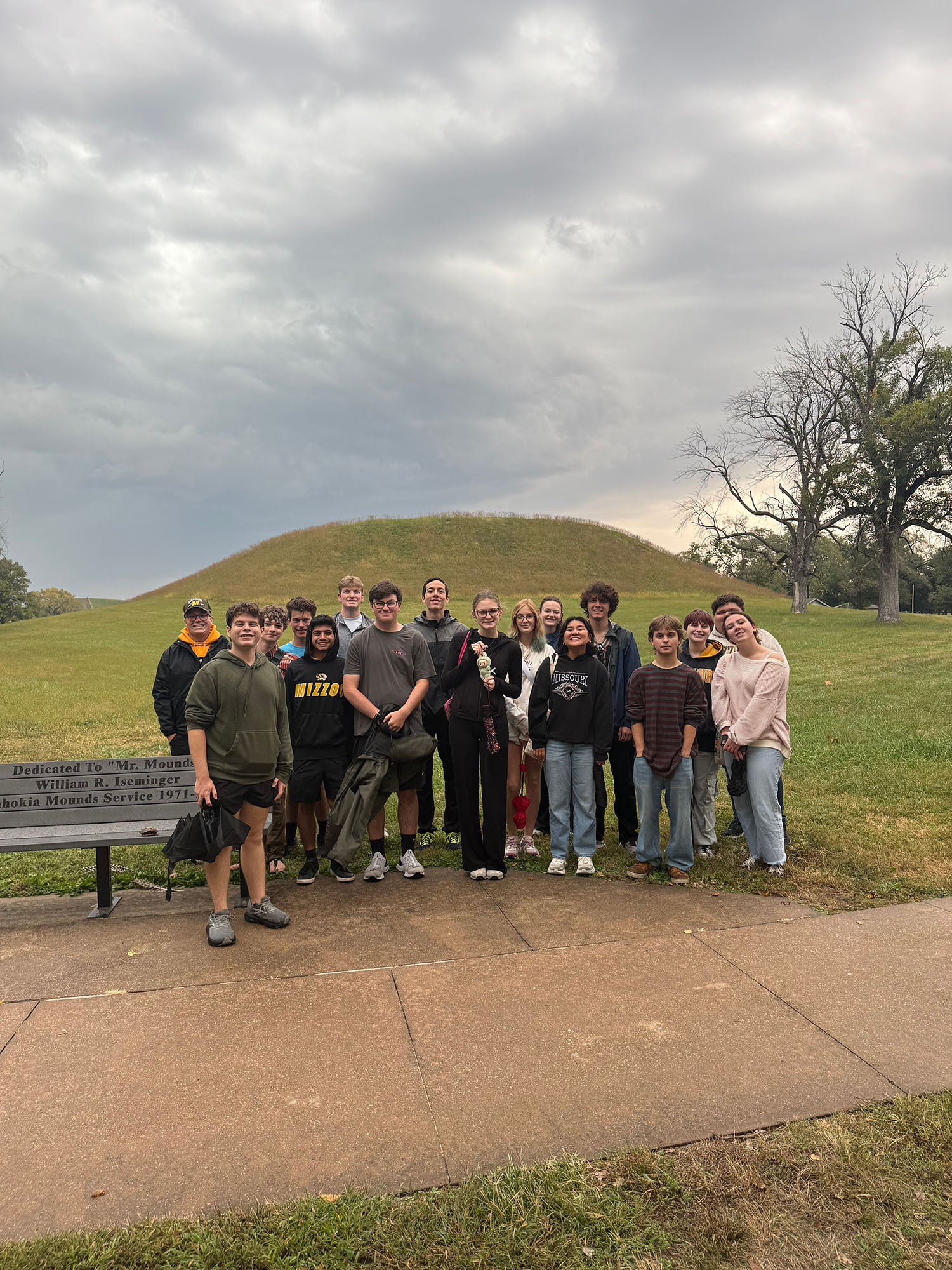 A group of students stand together and smile outdoors.