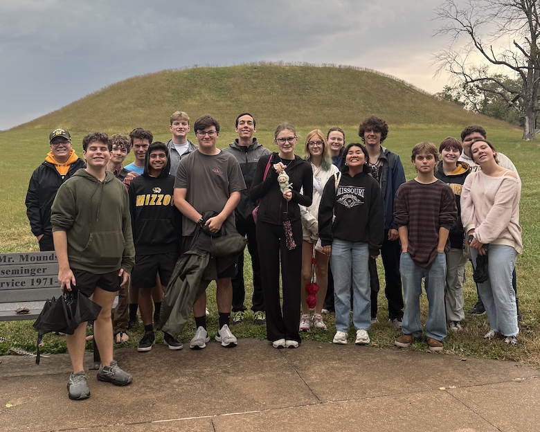 Students on a field trip stand in front of Kahokia Mounds. 