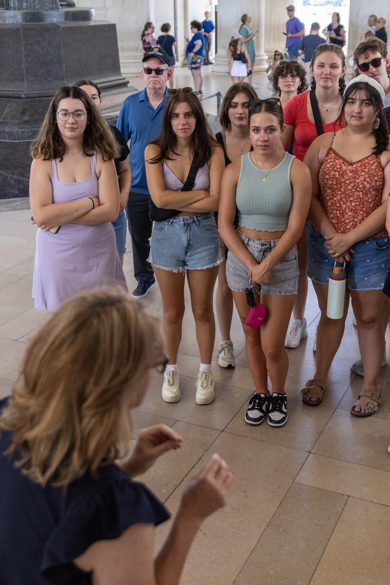 A group of college students listen to their professor lecture in the rotunda of the Jefferson Memorial in DC.