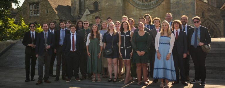 A group photo of students and faculty on the Handa Terrace at Oxford