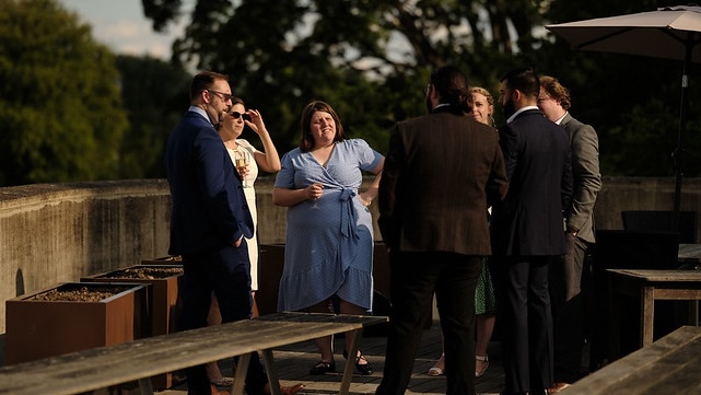 A group of students share a conversation on an Oxford veranda.