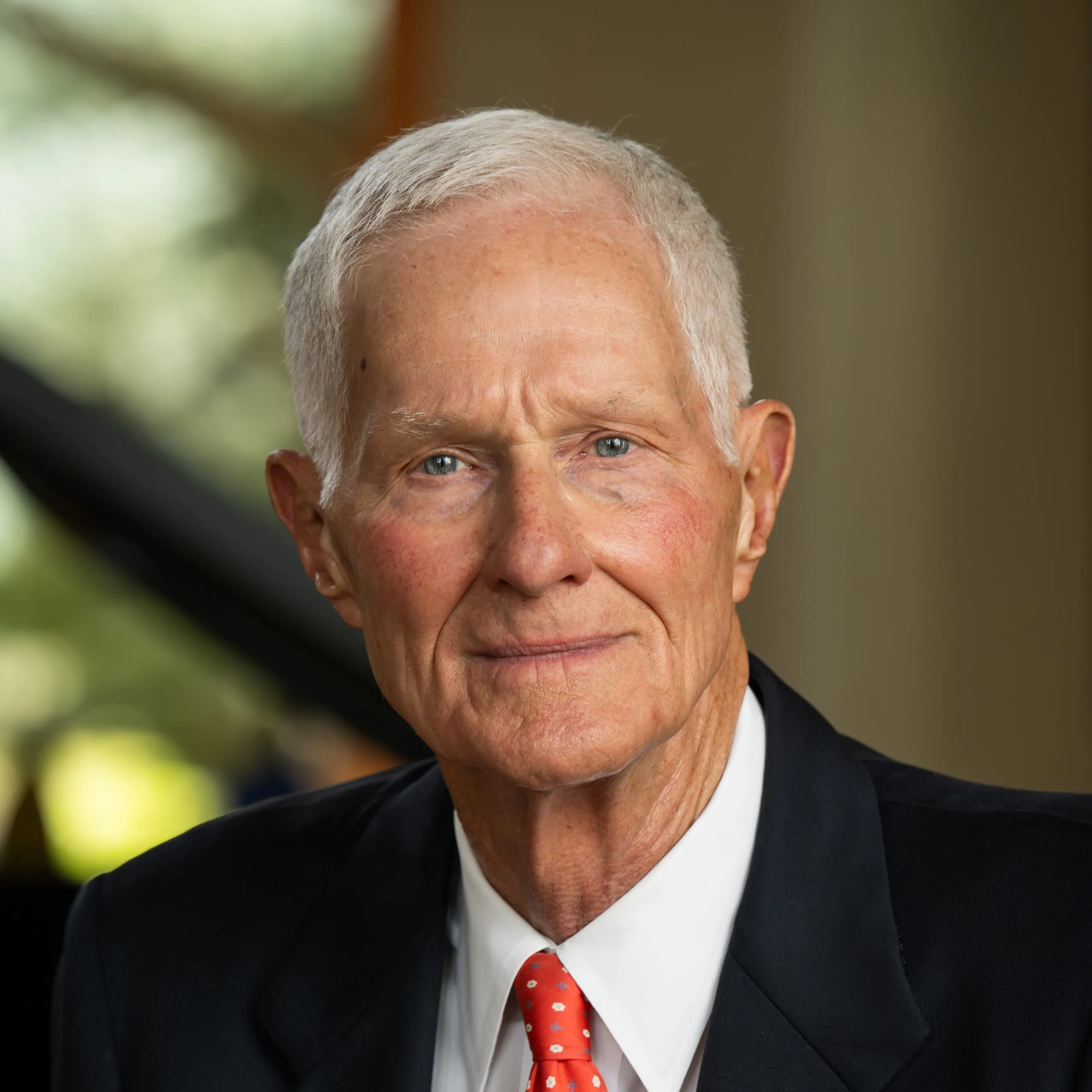 Man in suit looks stoically at the camera